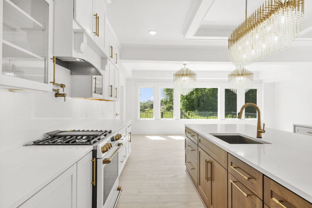 Kitchen range wall with gold pot filler and white cabinets