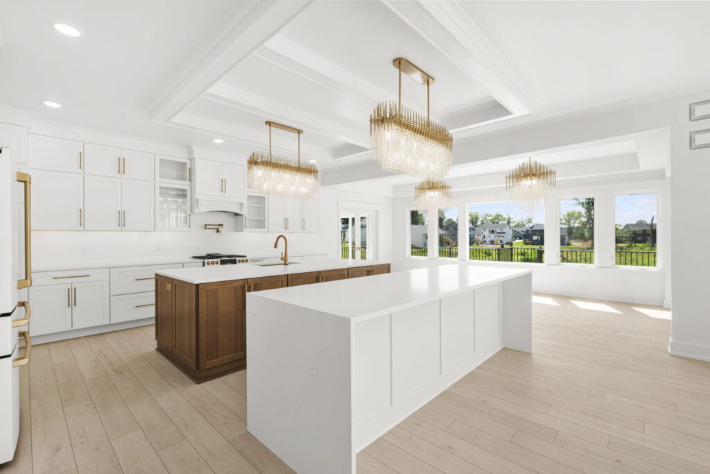 Bright kitchen with large white island and gold chandeliers