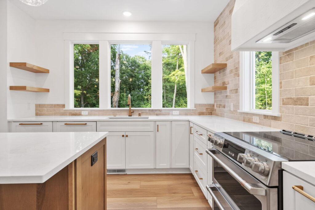 Kitchen sink view with large windows and open shelves