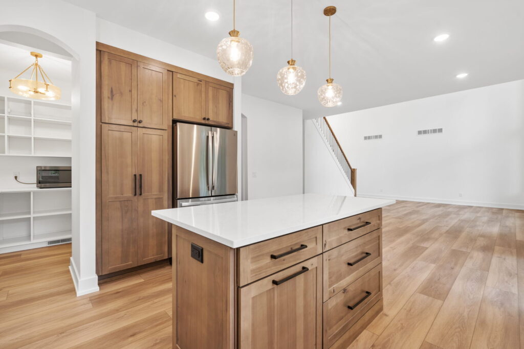 Kitchen island with wood cabinets and pendant lighting