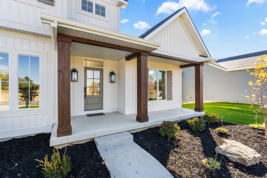 Entryway of white custom home with wood front door