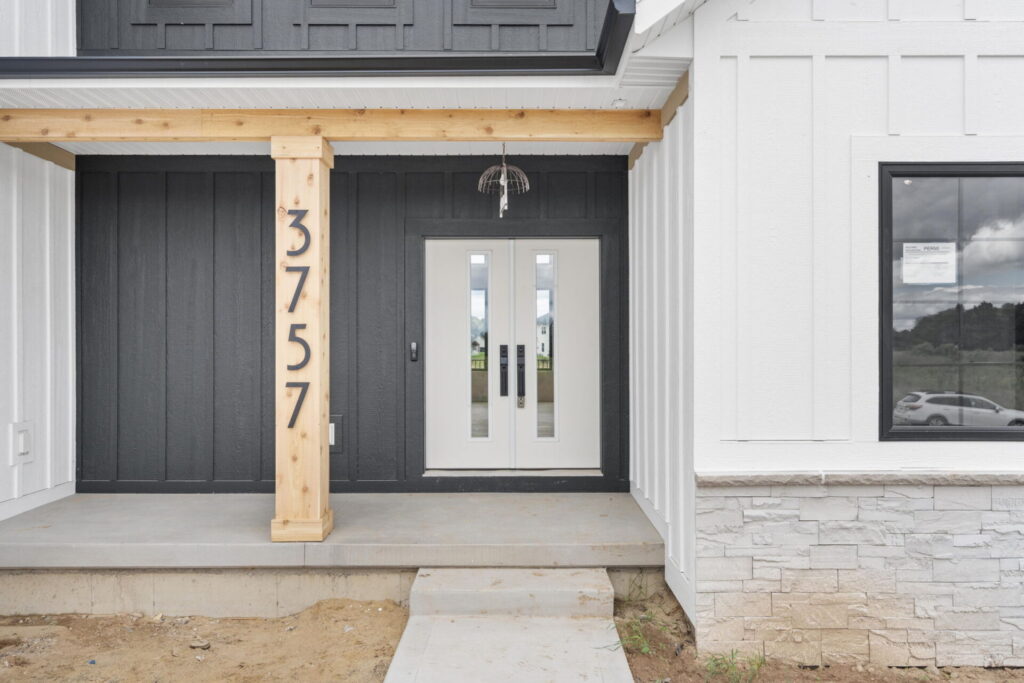 Modern farmhouse entry with white double doors and wood post