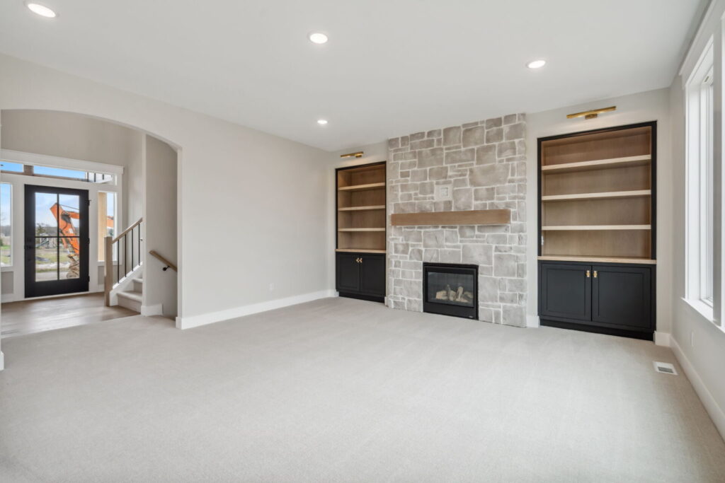 a modern living room with neutral colors and built-in bookcases
