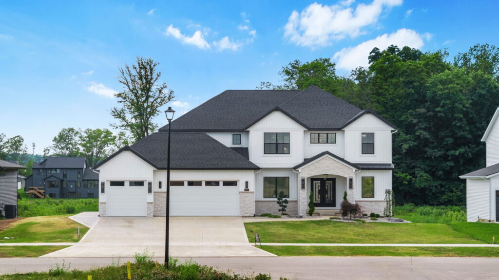 Front exterior of white two-story custom home with stone accents