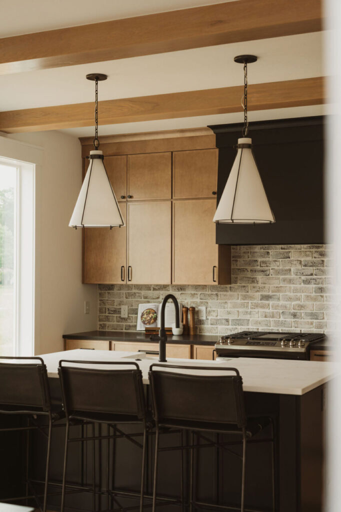 Kitchen island with black faucet and brick backsplash