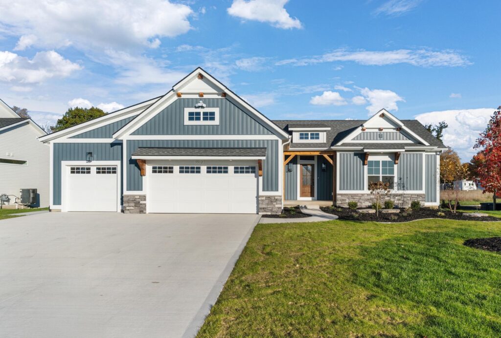Blue custom ranch home with three-stall garage